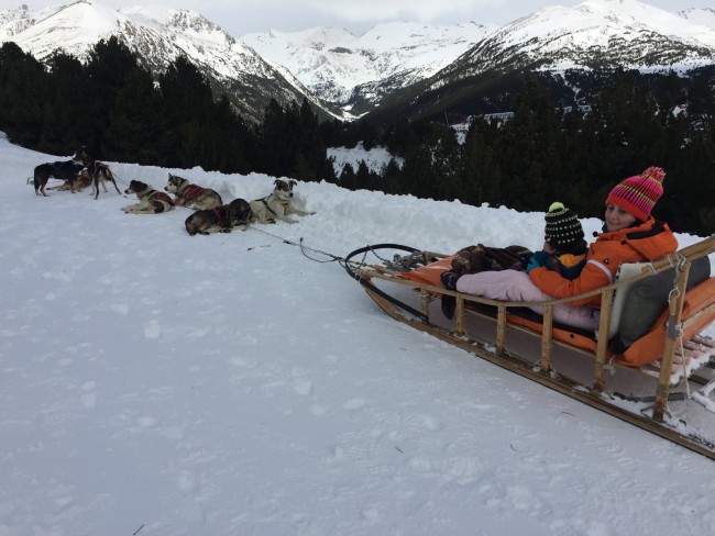 Eric y Sandra sentados en el trineo. Trineo tirado por perros, mushing en Grandvalira, Andorra.